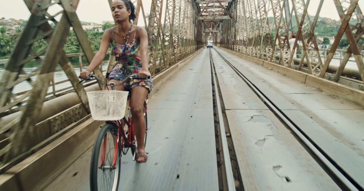 Personagem de Aline Brunne andando de bicicleta - Cena do filme Café com Canela